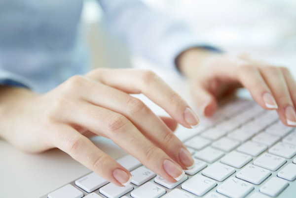 Woman typing on white keyboard