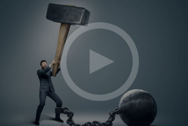 Man holding giant hammer with weight chained to his leg