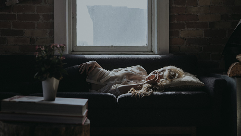 Woman laying ill on couch